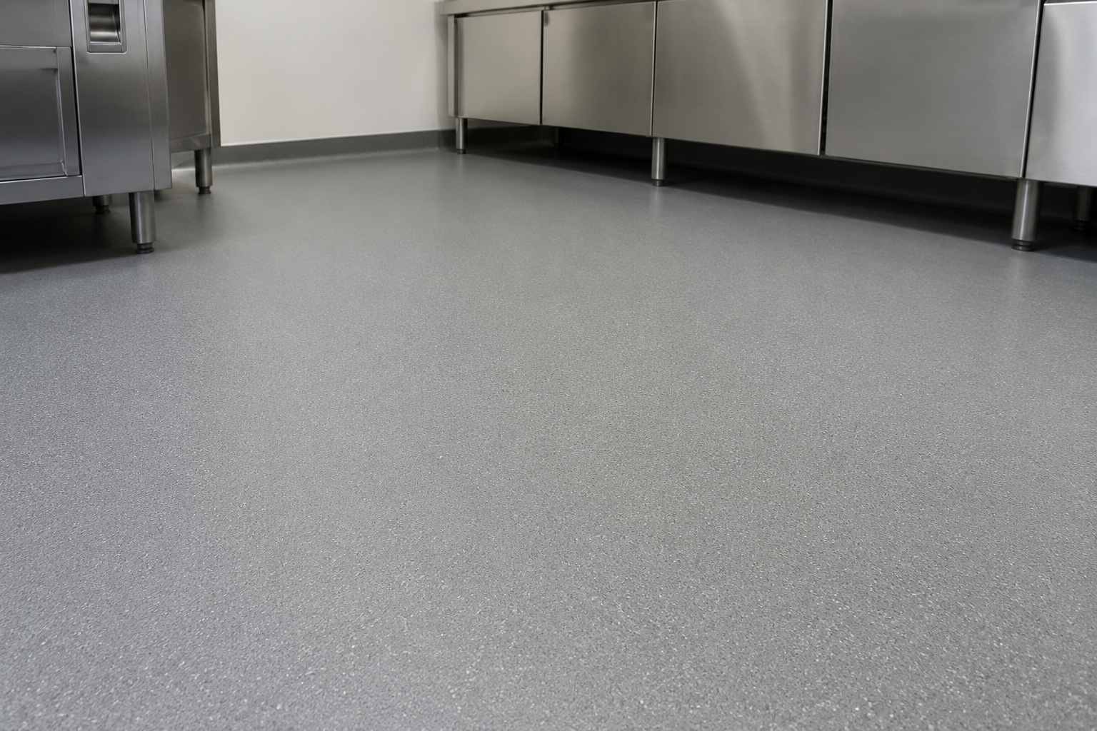 Slip-resistant grey safety flooring in a stainless steel commercial kitchen
